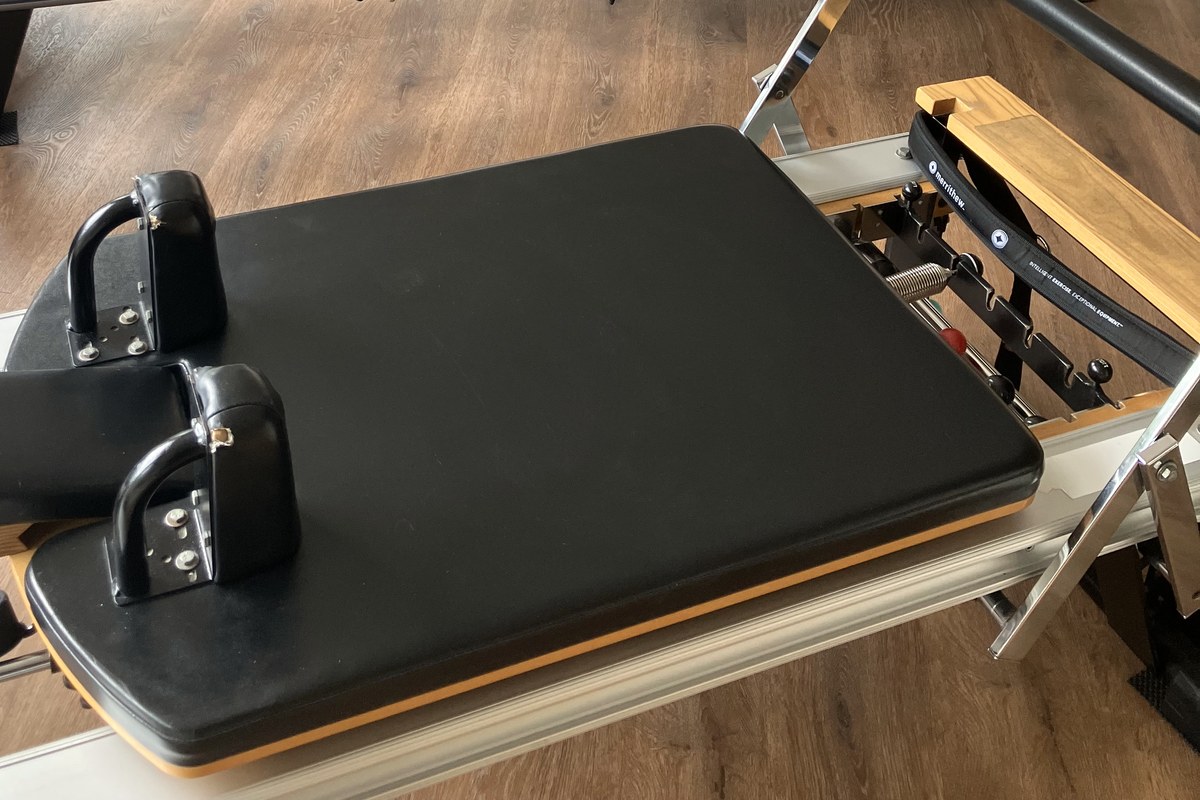 Close view of a padded reformer carriage and shoulder rests.
