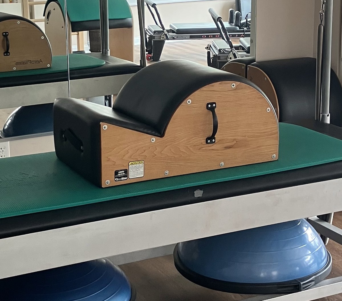 A wooden spine corrector on a teal mat on the Cadillac.